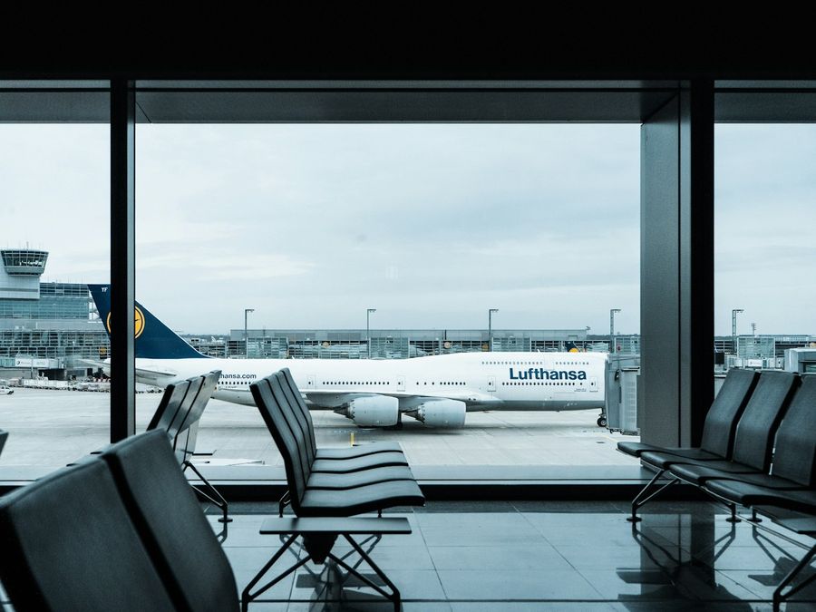 Sala de embarque de aeroporto com poltronas cinzas durante o dia